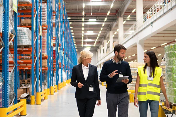 Operations manager and team members discussing roles on a warehouse floor